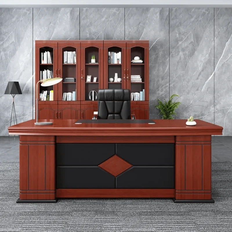 1600mm executive office table in a warm cherry wood finish, featuring an integrated black leather writing pad inlay, a matching L-shaped side return extension desk, and a black front modesty panel accented with a geometric diamond wood pattern.