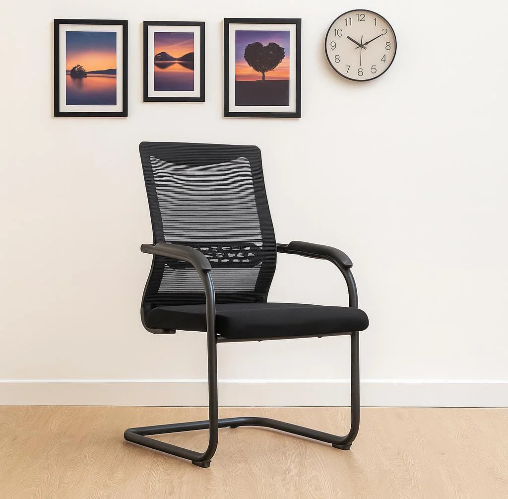 Mid-back mesh waiting chair featuring a rectangular black mesh backrest with a perforated horizontal lumbar support band, fixed curved armrests, a padded black fabric seat, and a black metal cantilever sled base.