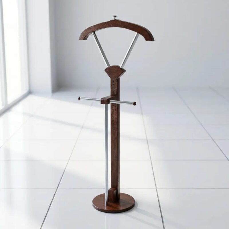 Modern freestanding wooden valet stand with a curved suit hanger, metal trouser bar, and a stable circular base in a minimalist white-tiled room.