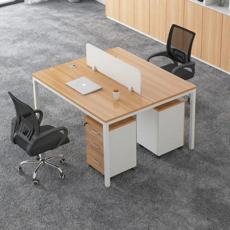 Modern 2-person modular office workstation with light wood grain tabletops, white privacy screen, and integrated mobile pedestal drawers in a professional open-plan setting.