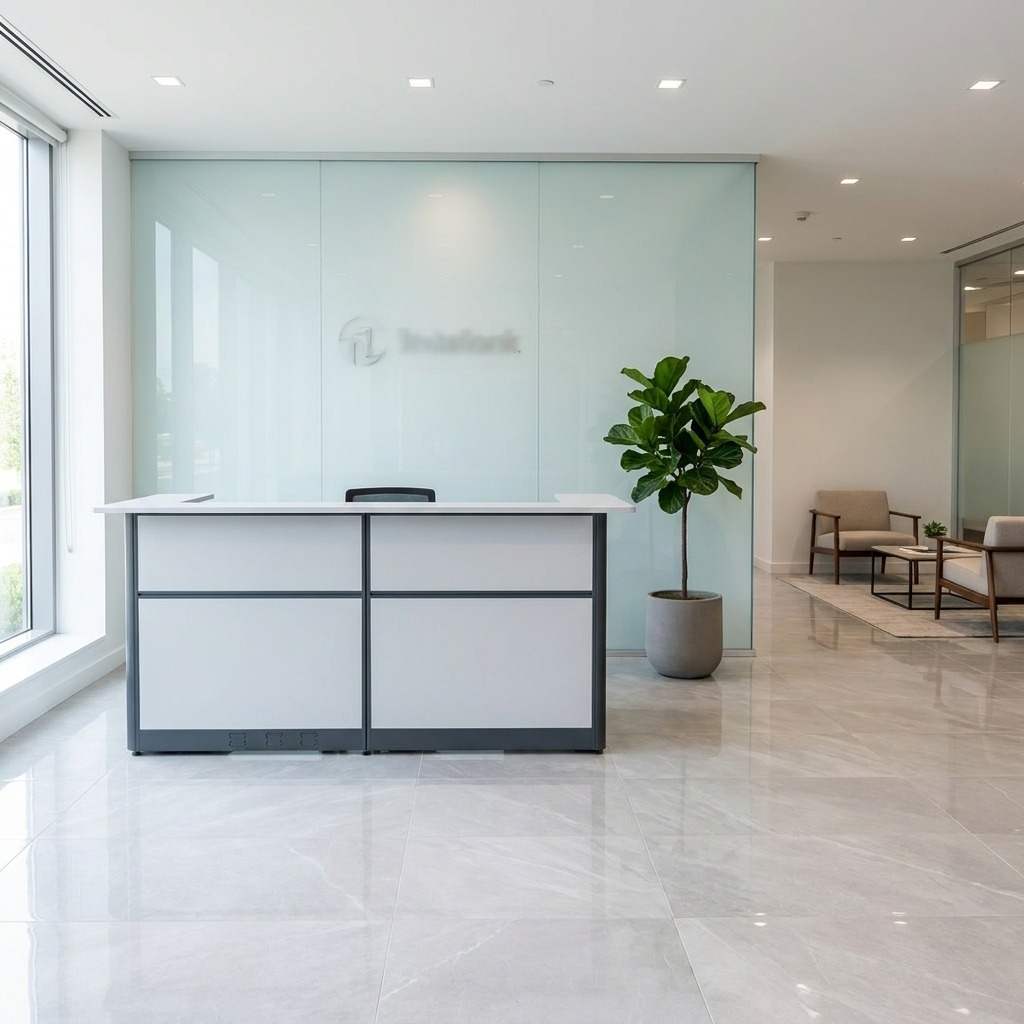 Modern white and grey modular reception desk with a raised transaction counter and charcoal grey trim, designed for professional corporate lobbies.