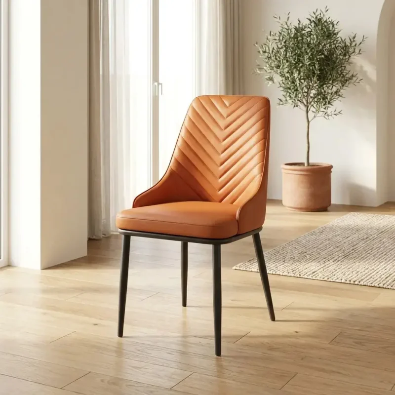 Elegant tan leather dining area chair with a chevron-quilted high back and matte black legs, styled in a minimalist, sun-drenched dining space for a high-end interior look.