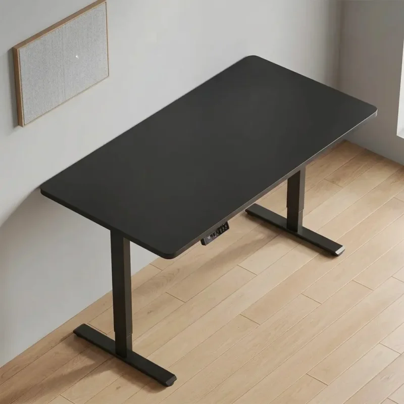 Black electric standing desk with height-adjustable T-leg frame and integrated digital control panel.