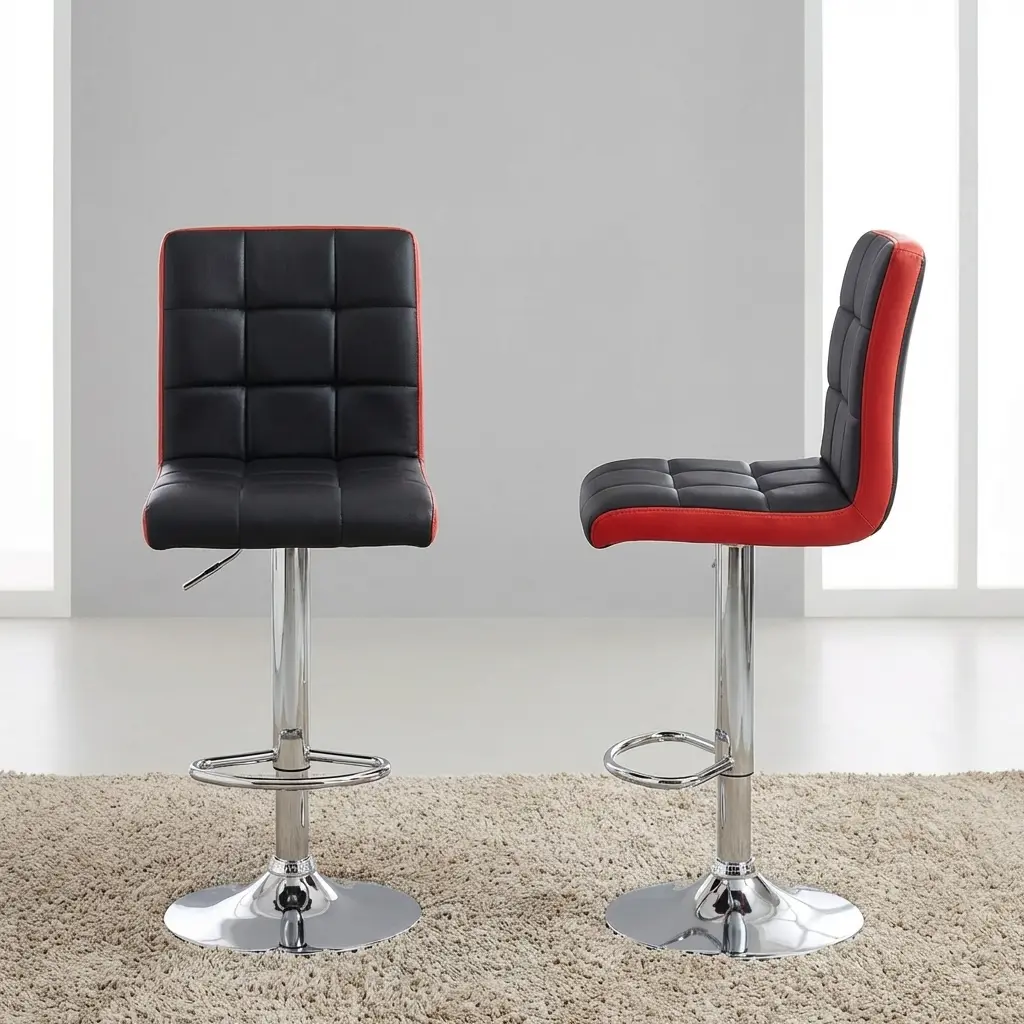 Modern adjustable swivel barstool in black and red faux leather with a tufted square-patterned seat, gas lift pedestal, chrome footrest, and round base at a kitchen counter.