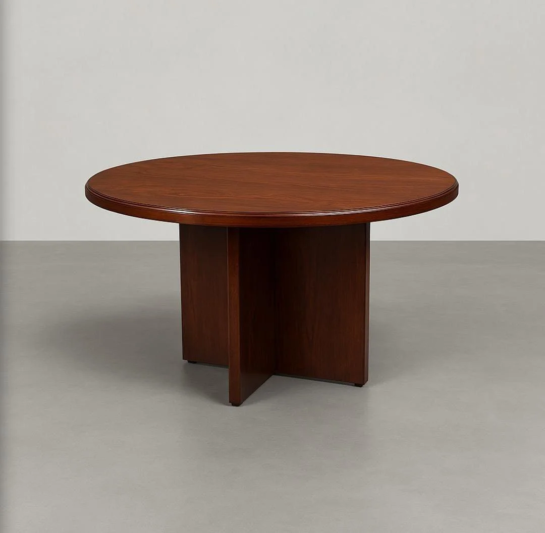 Round conference table in a rich cherry wood veneer finish, featuring a thick, circular tabletop with a classic bevelled edge detail, supported by a central, intersecting X-shaped wooden pedestal base.