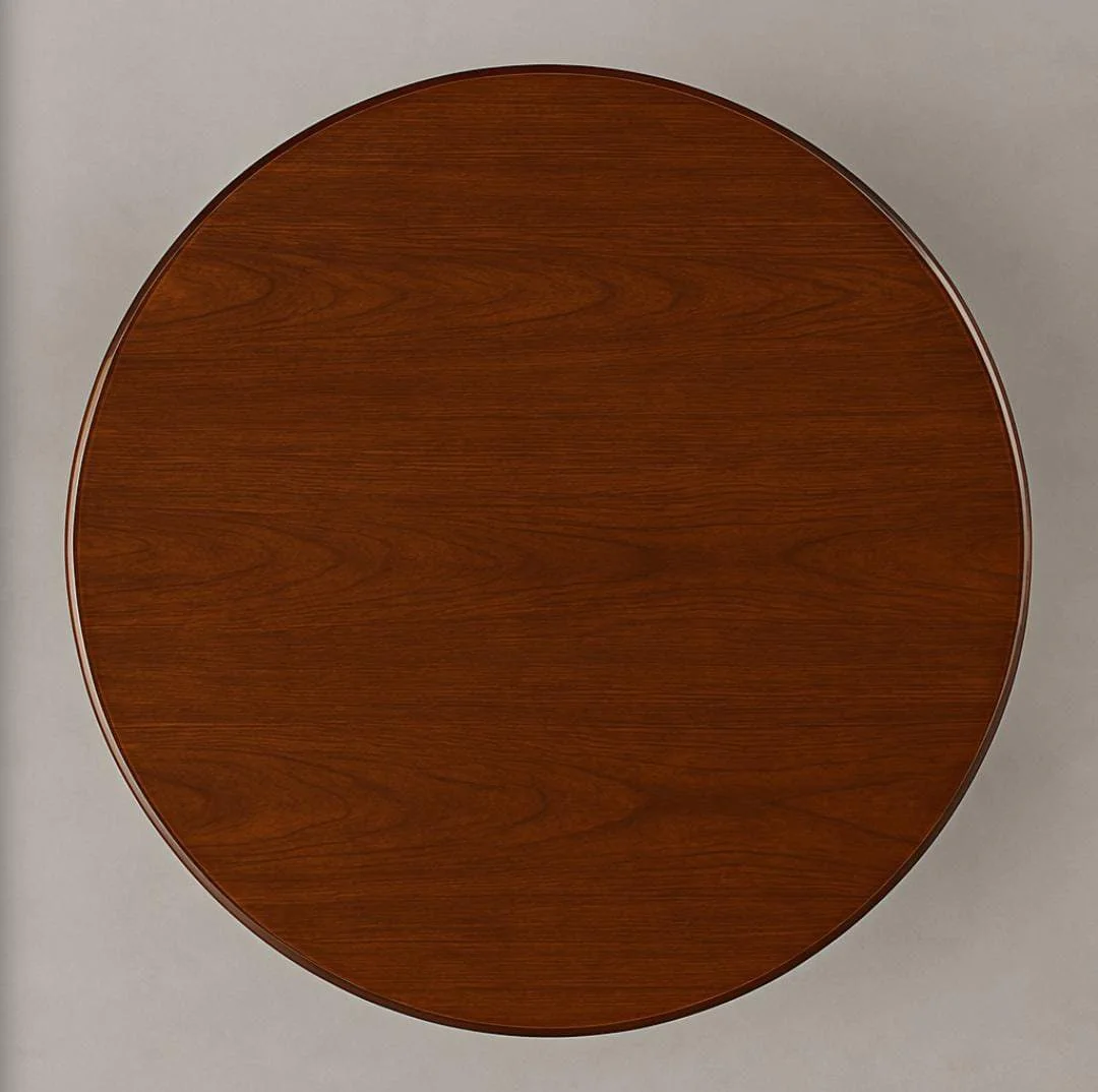 Round conference table in a rich cherry wood veneer finish, featuring a thick, circular tabletop with a classic bevelled edge detail, supported by a central, intersecting X-shaped wooden pedestal base.
