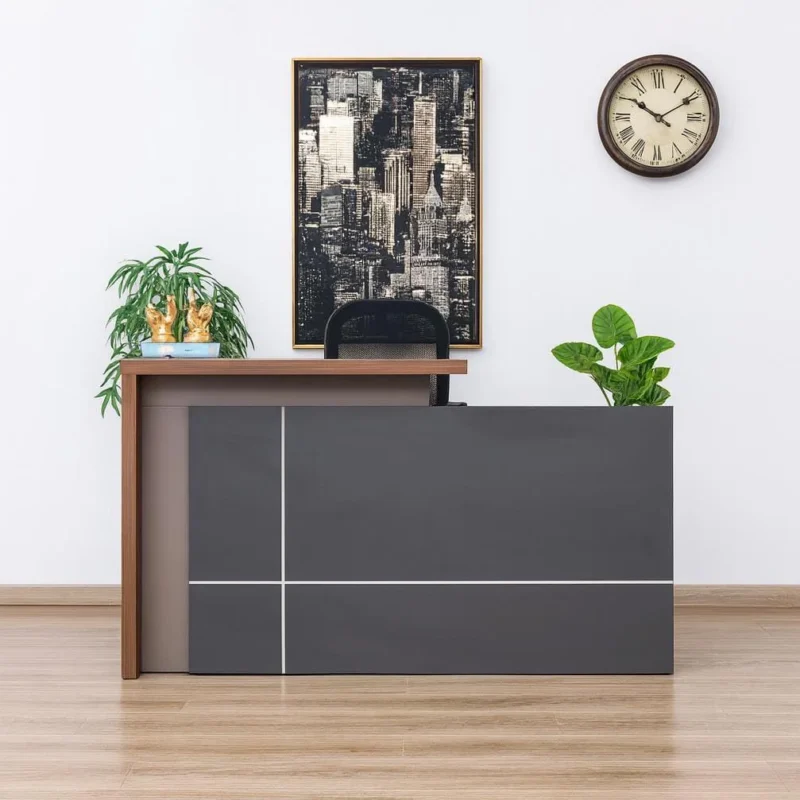 1800mm reception office desk featuring a dual-level design with a matte dark grey chassis, a medium-toned wood grain transaction counter, an integrated writing desktop with a rectangular grommet, and a built-in left pedestal storage unit comprising a lockable drawer and an open cabinet door revealing an interior shelf.