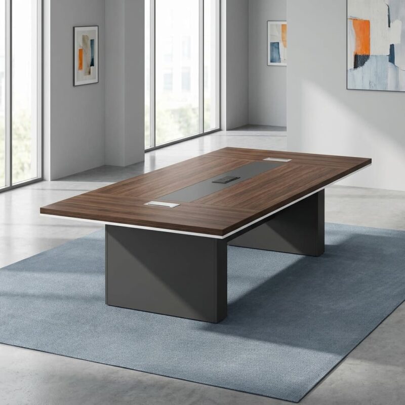 2.4m boardroom table featuring a premium walnut wood veneer tabletop with a modern white-edge trim, a central integrated grey cable management track with three pop-up power and data modules, supported by two robust grey rectangular pedestal bases.