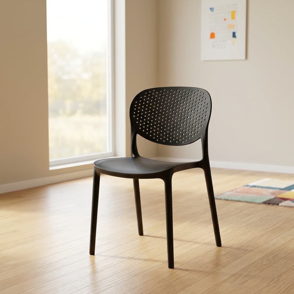 Black plastic stackable chair featuring a molded single-piece matte polypropylene frame, a curved oval backrest patterned with breathable perforations, an open lower back design, a gently contoured seat pad, and four integrated tapered legs.