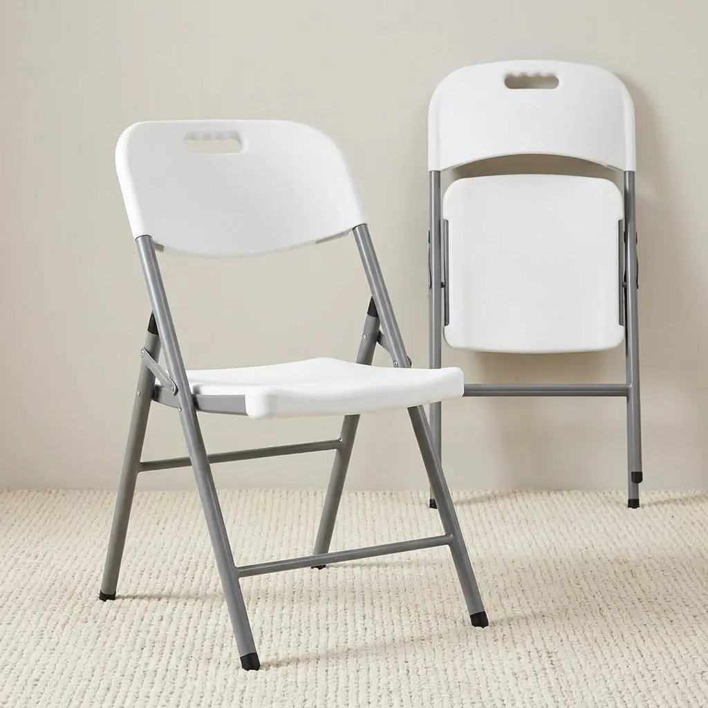 White foldable camping chair featuring a textured white molded plastic seat and backrest with an integrated carrying handle cutout, supported by a durable grey powder-coated steel folding frame with protective rubber foot caps.