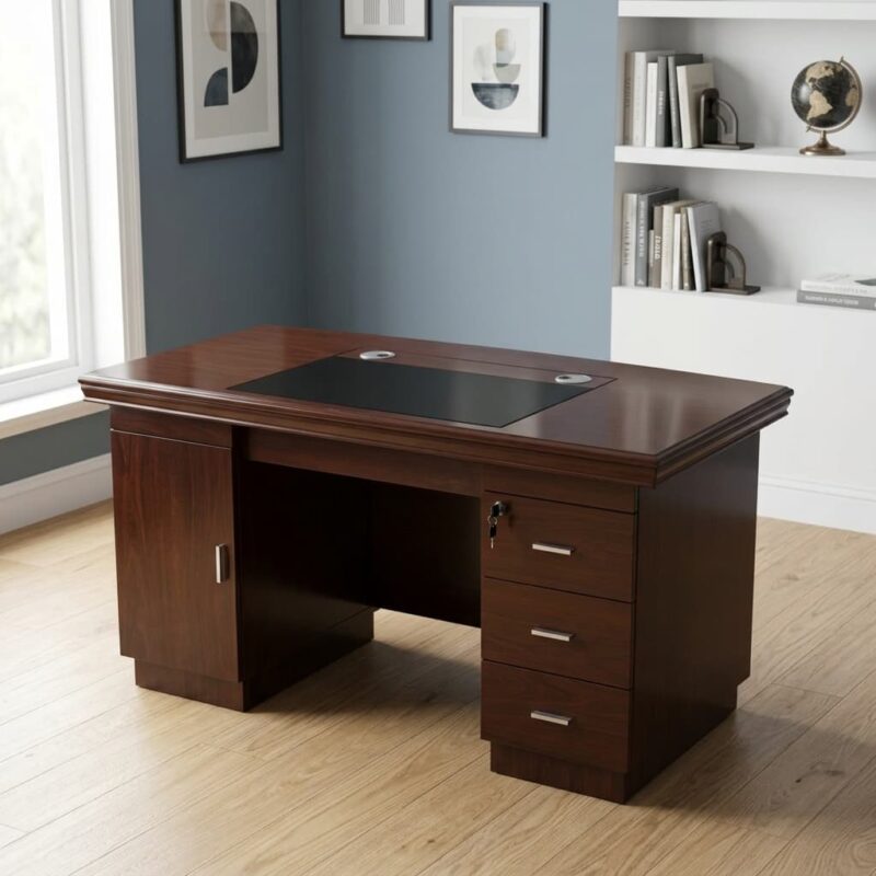 1.2 Meters Executive Office Desk finished in a rich reddish-brown wood veneer, featuring a thick tabletop with classic multi-tiered bevelled edges, an embedded black leatherette writing pad with two circular silver cable grommets, a left-side storage cabinet, and a right-side three-drawer pedestal with a central key lock system and brushed silver handles.