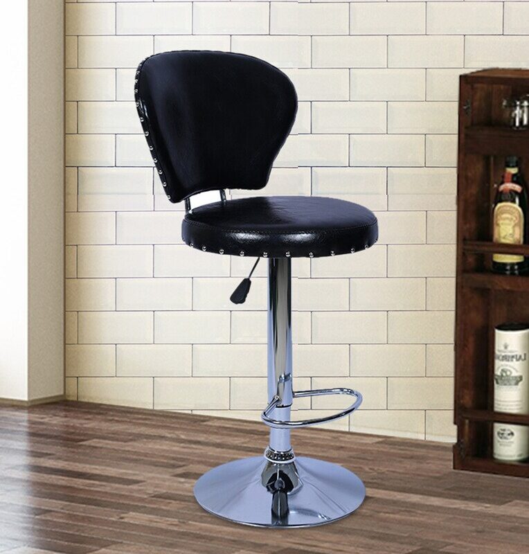 Leather swivel barstool -black featuring a curved, padded backrest and a thick round seat cushion upholstered in shiny black faux leather with silver chrome rivet stud trim, supported by an adjustable pneumatic chrome pedestal stem with a teardrop lever, an integrated semi-circular chrome footrest, and a polished chrome trumpet base.