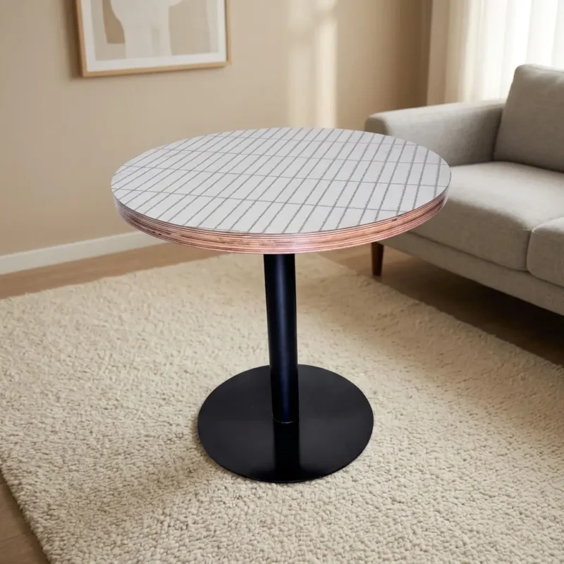 White circular dining table featuring a tabletop with a subtle linear grid pattern and exposed layered plywood edge detail, supported by a central black metal pedestal column and a heavy-duty flat circular base.