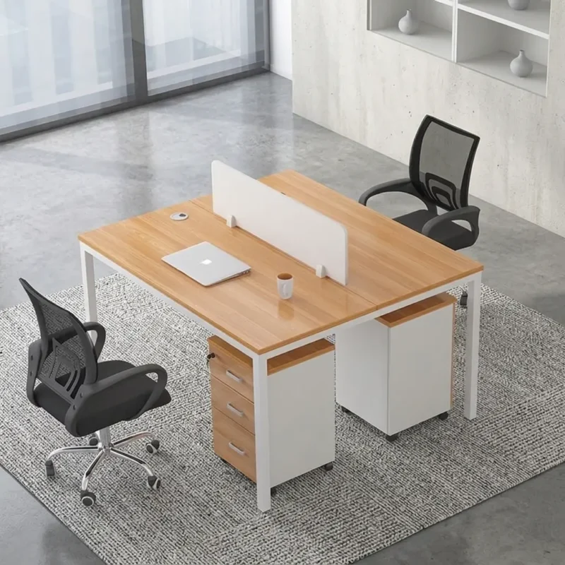 Two-seater modular workstation featuring a face-to-face dual desk configuration in a light oak wood and white finish, a central white privacy divider screen, integrated desktop cable grommets, white metal leg frames, and two matching mobile drawer pedestals for individual storage.
