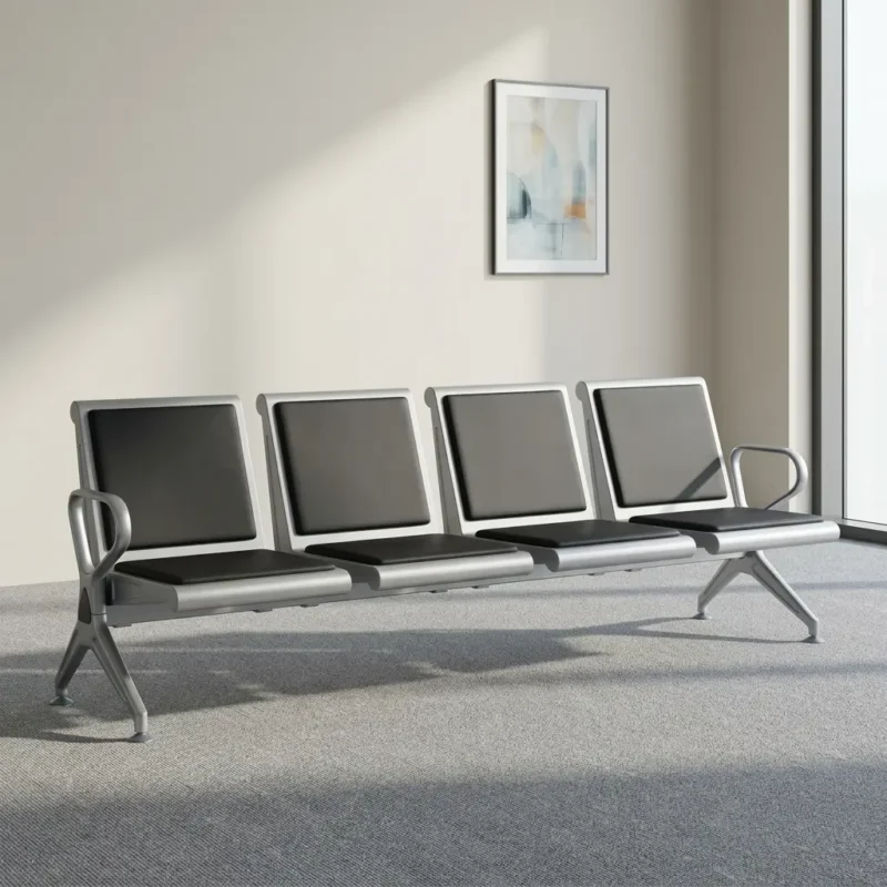 Four-seater waiting bench featuring four contoured seats with black padded faux leather cushions, a silver powder-coated metal frame, curved metallic armrests, and a heavy-duty beam structure supported by angled metal legs.