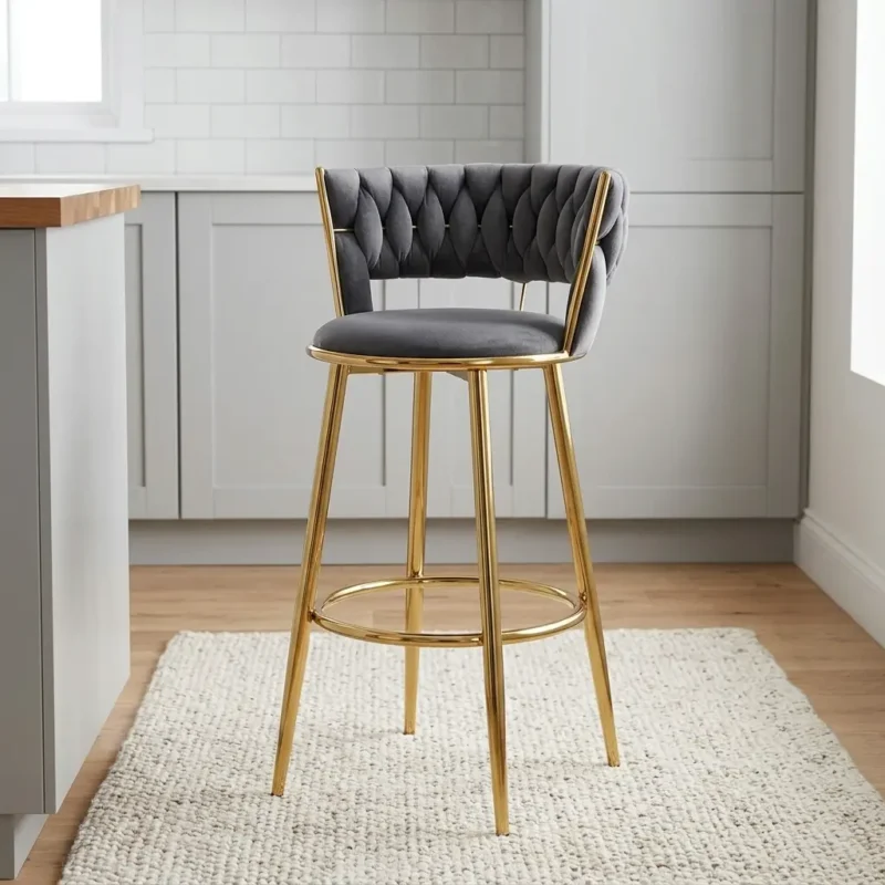 Gray fabric bar stool featuring a plush charcoal grey velvet seat, woven tufted barrel backrest with metallic gold wire framing, circular integrated footrest ring, and sleek gold-finished metal legs.