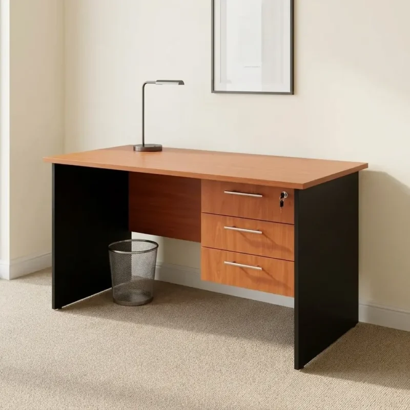 1.0m standard size office table featuring a warm cherry wood laminate top, an integrated right-side suspended pedestal with three drawers, sleek silver straight bar handles, a top-drawer security key lock, a matching wooden modesty panel, and solid black side panel supports.