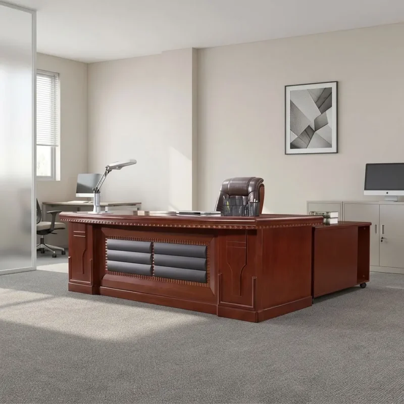 Executive 2m mahogany office table featuring a classic mahogany wood-veneer finish, a spacious rectangular main desk surface, a front modesty panel accented with cushioned dark leatherette panels and slatted timber detailing, an attached side-return credenza cabinet, built-in wire management grommets, and a sturdy solid wooden pedestal base.