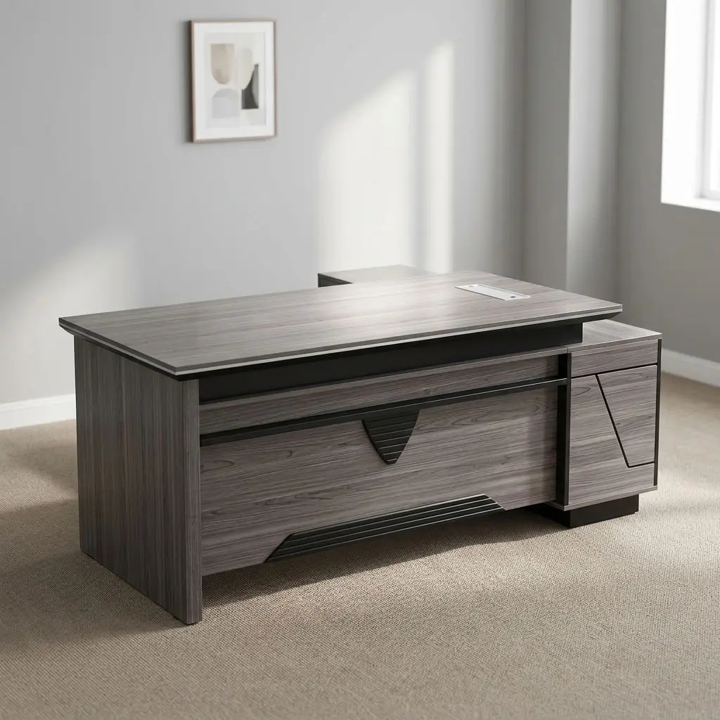 L-shaped 1600mm Office Table featuring a contemporary grey wood-grain laminate finish, an integrated desktop flip-top cable management box, a front modesty panel with geometric black accent detailing, a side return extension unit with integrated cabinet storage, and solid panel-style engineered wood base supports.