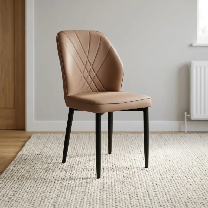 Brown leather dining chair featuring supple light tan-brown leatherette upholstery with cross-hatched accent stitching along the curved inner backrest, a cushioned contoured seat, an armless side chair profile, and matte black powder-coated steel tapered legs.
