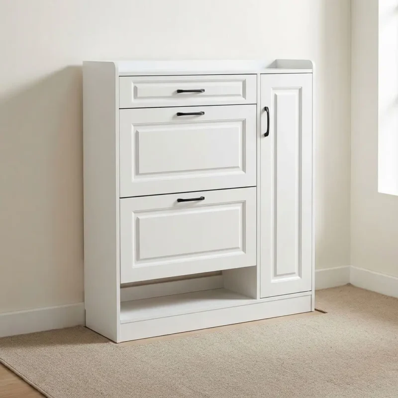 Modern wooden shoe rack featuring crisp white engineered wood construction with traditional recessed panel detailing, a top utility pull-out drawer, two tilt-down shoe compartment drawers, a tall side cabinet door with black handle hardware, an open bottom storage cubby, and a solid plinth base.
