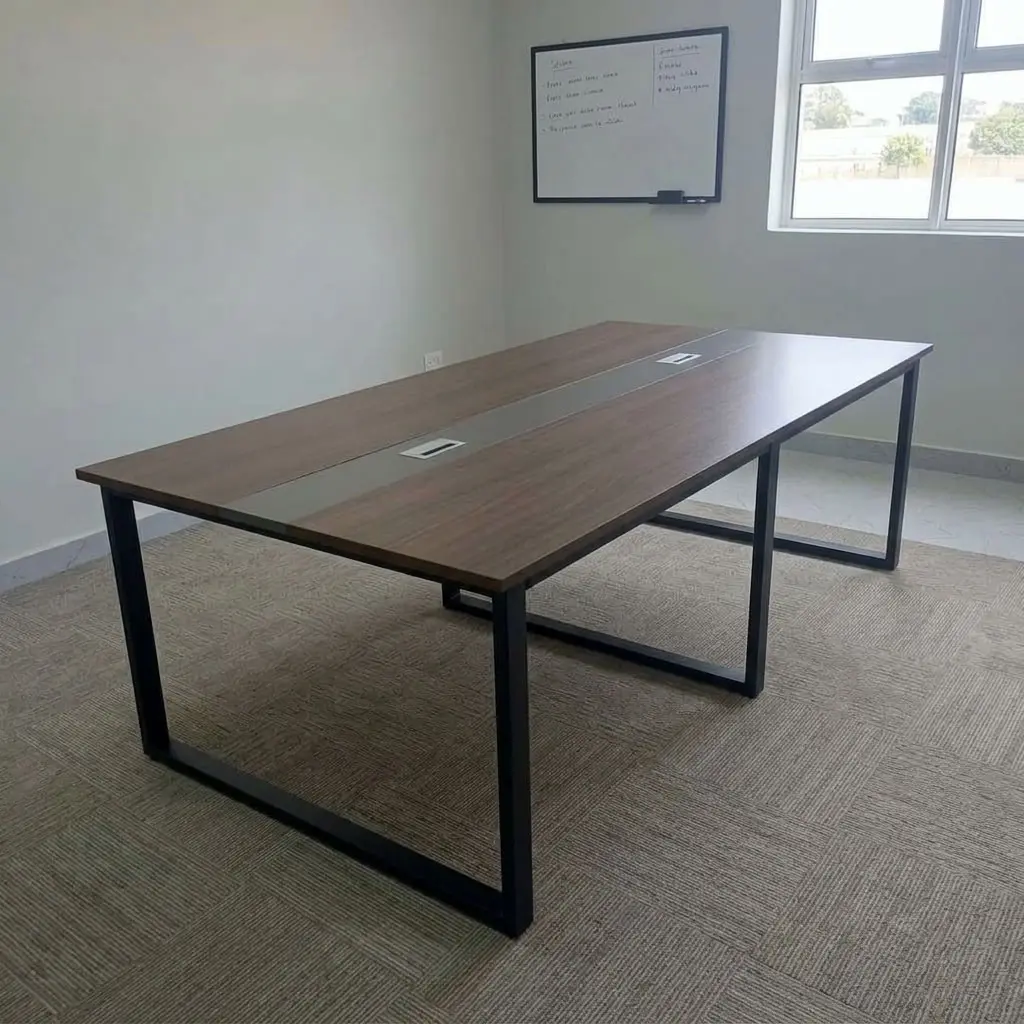 2.4metres boardroom table featuring a walnut wood-grain laminate desktop, a central grey cable management raceway inlay with integrated pop-up power/data access covers, and heavy-duty black powder-coated steel O-frame loop legs.