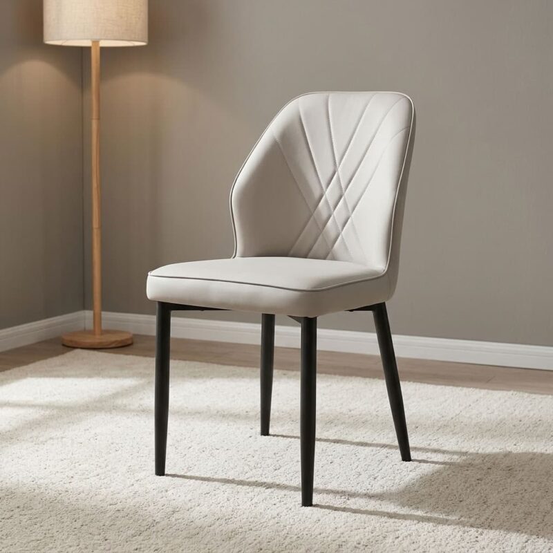 Modern leather dining chair featuring light gray faux leather upholstery with fan-style accent stitching on the inner backrest, a padded bucket-style seat with subtle side curves, an armless profile, and slim tapered black powder-coated metal legs.